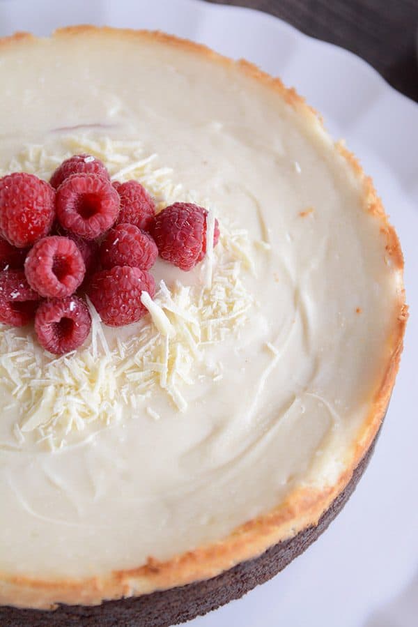 Top view of a full white chocolate raspberry cheesecake topped with fresh raspberries. 