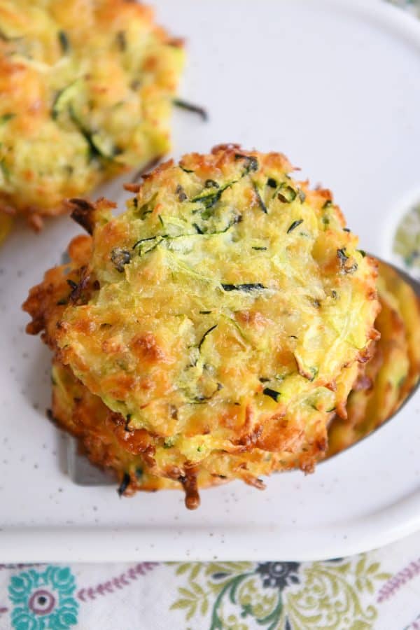 Top down view of a stack of baked cheesy zucchini bites.