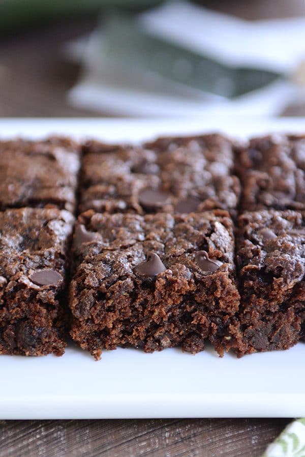 A white platter of chocolate chip zucchini brownies.
