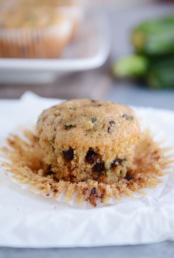 An unwrapped chocolate chip zucchini muffin sitting on a napkin.