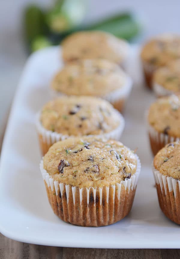 Chocolate chip zucchini muffins on a white platter.